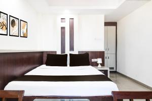 une chambre avec un grand lit blanc avec des oreillers noirs dans l'établissement Super Hotel O Park Street Inn, à Rānchī 21 autres photos