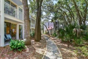 a walkway in front of a house with trees at Villa 453 in Jekyll Island