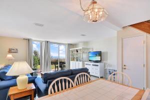 a living room with a blue couch and a tv at Villa 107 in Jekyll Island