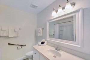 a white bathroom with a sink and a mirror at Villa 107 in Jekyll Island +21 photos