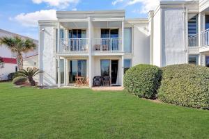 a large white house with a lawn in front of it at Villa 107 in Jekyll Island