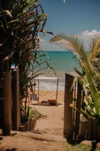 a beach with chairs and the ocean in the background at Pousada Casa Mar Pé na Areia in Caraíva