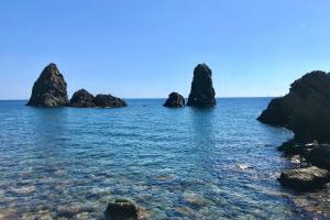 a view of the ocean with rocks in the water at Casa Reale in Gravina di Catania