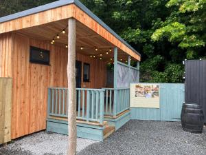 a wooden building with a porch and a sign at Tigh-Na-Mara Hotel in Sandhead