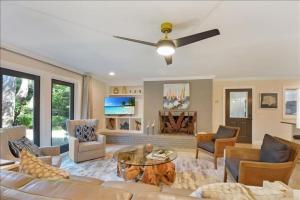 a living room with a couch and a ceiling fan at Woodlawn in Jekyll Island