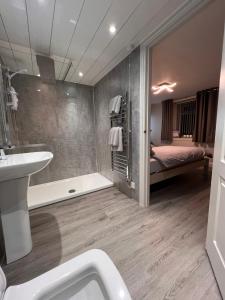 a bathroom with a tub and a sink and a bed at Tigh-Na-Mara Hotel in Sandhead