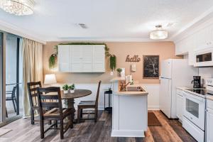 a kitchen and dining room with a table and chairs at Villa 401 in Jekyll Island