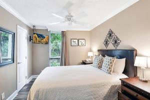 a bedroom with a bed and a ceiling fan at Villa 401 in Jekyll Island +22 photos