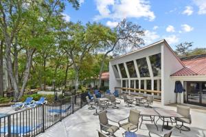 a patio with chairs and tables and a pool at Villa 401 in Jekyll Island