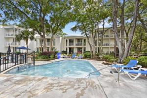 a swimming pool with chairs and a resort at Villa 401 in Jekyll Island