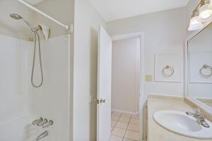 a white bathroom with a sink and a shower at Villa 229 in Jekyll Island +11 photos
