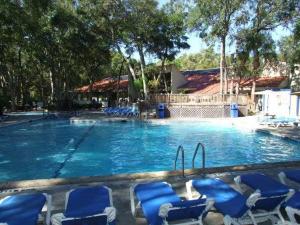a large swimming pool with blue chairs in it at Villa 229 in Jekyll Island