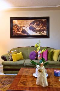a living room with a green couch and a table at Casa Kinich in Guadalajara