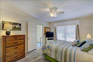 ein Schlafzimmer mit einem Bett und einem Deckenventilator in der Unterkunft Seaview Cottage in Jekyll Island + 38 Fotos
