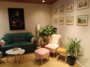 a living room with a green couch and plants at Ferienwohnung Studio 62 in Rastede