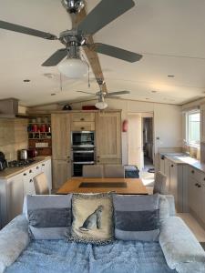 a kitchen with a table and a ceiling fan at Lodge by the Sea in Kinmel Bay