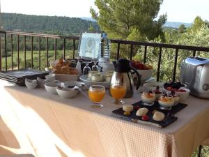 a table with a buffet of food and drinks at Le Logis in Gordes