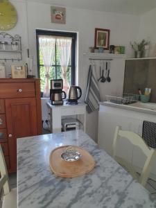 eine Küche mit einem Tisch und einem Teller darauf in der Unterkunft La Maison de Jeanne in Lesparre-Médoc + 12 Fotos