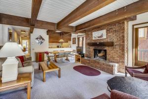 a living room with a fireplace and a brick wall at Iconic Ski Town Charm - Unbeatable Location in Aspen