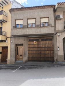 a building with two garage doors and a balcony at Casa Parador De Santa María in Villarrobledo
