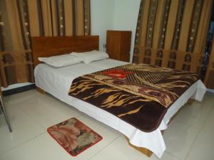 ein Schlafzimmer mit einem Bett mit einer Decke darauf in der Unterkunft Unity Inn in Cox's Bazar