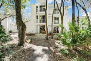 a large white house with trees in front of it at Villa 435 in Jekyll Island