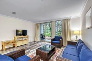 a living room with a blue couch and a tv at Villa 452 in Jekyll Island