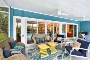 a screened in porch with chairs and a table at Sandpiper Hideaway in Jekyll Island