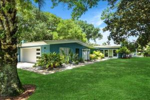 a house with a green lawn in front of it at Sandpiper Hideaway in Jekyll Island