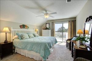 a bedroom with a bed and a ceiling fan at Spectacular Sunrise in Jekyll Island +28 photos