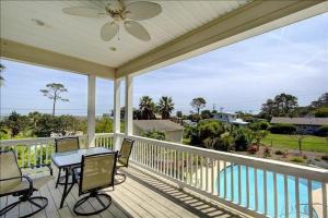 a screened in porch with a table and chairs on it at Spectacular Sunrise in Jekyll Island