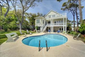 a large house with a swimming pool in front of it at Spectacular Sunrise in Jekyll Island