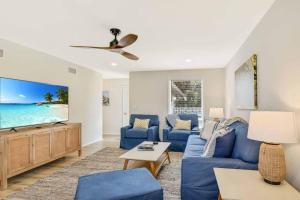 a living room with a blue couch and a tv at Spring Cottage in Jekyll Island