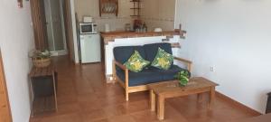 a living room with a blue couch with two pillows at Bungalows Sierra San Benito in Cala