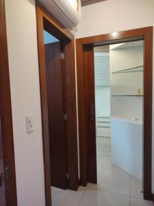 a hallway with a glass door and a refrigerator at Refúgio aconchegante no coração de Urubici in Urubici