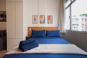 een slaapkamer met een blauw bed met blauwe kussens bij SUH Copacabana 43 New Confort in Rio de Janeiro