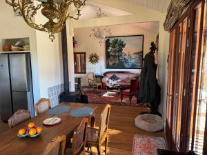 a dining room with a table and a living room at Cabanon Régina in Lège-Cap-Ferret
