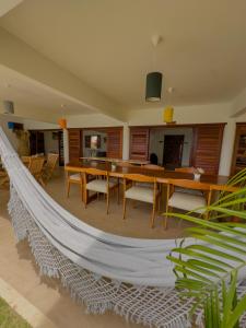 a hammock in a living room with a table and chairs at Villa Paririö in Canoa Quebrada