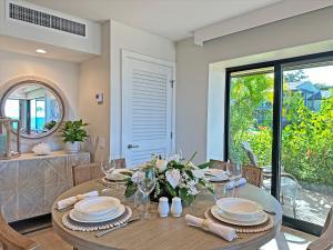 a dining room with a table with plates and glasses at Panoramic Ocean Views! Remodeledredecorated! Very Pretty Corner Ground Floor 2 Bedroom2 Bath in Wailea