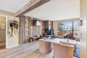 a living room with a table and chairs at Riverside Condo, with a Pool & Hot Tub - Steps to Town in Aspen