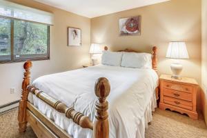 a bedroom with a large bed and a window at Riverside Condo, with a Pool & Hot Tub - Steps to Town in Aspen +43 photos