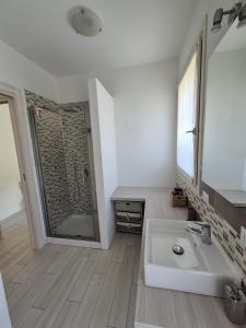a white bathroom with a sink and a shower at A casa di Elena in Lesa