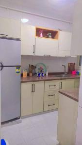 une cuisine avec des armoires blanches et un réfrigérateur dans l'établissement رزق هاوس, à Ash Shūnah ash Shamālīyah 9 autres photos