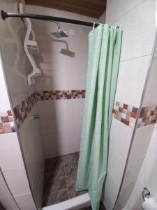 eine Dusche mit grünem Duschvorhang im Bad in der Unterkunft Apartamento Hogar Caribeño 2H con AA in Santa Marta