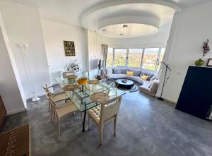 een woonkamer met een glazen tafel en stoelen bij one bedroom plus 1 extra room Nomad Dreams N6 in Cascais mountain view in Cascais +32 foto's