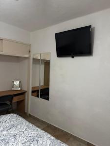 a bedroom with a flat screen tv on a wall at San Carlos Sonora Casa Caracol Condominio in Guaymas