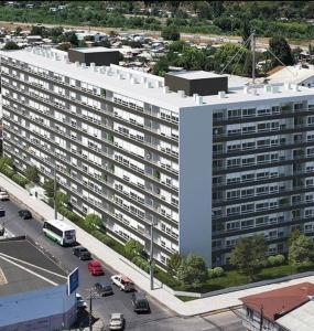 Una vista aérea de un gran edificio blanco con estacionamiento. en Departamento central Temuco, en Temuco
