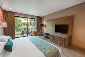 普拉亚卡门The Yucatan Playa Del Carmen, Tapestry Collection By Hilton的一间配有床和平板电视的酒店房间
