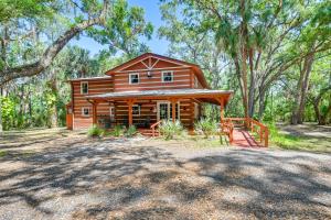 a log cabin in the woods with a tree at Spacious Sebring Family Cabin with Fun Barn and Yard! in Sebring