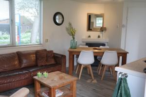 ein Wohnzimmer mit Sofa und Tisch in der Unterkunft Landelijk gelegen chalet aan de Vecht vlakbij Amsterdam in Nigtevecht
